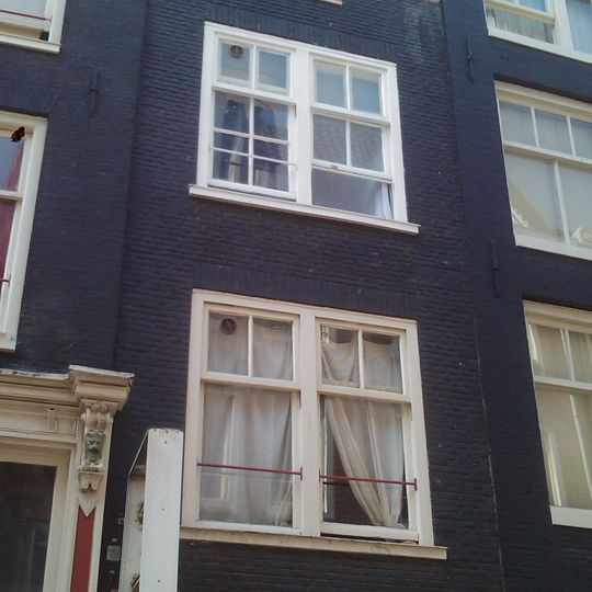 Huis, vanwege de 18e-eeuwse aanzetkrullen en afdekking van de klokvormige geveltop