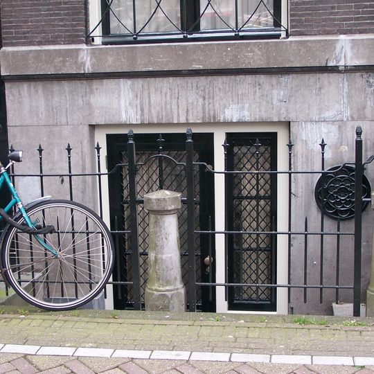 Pand met gevel onder rechte lijst met consoles, waarvoor vier stoeppalen