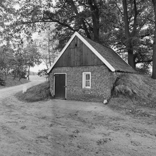 Gedeeltelijk ingegraven stenen gebouwtje onder pannen zadeldak