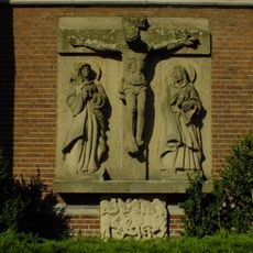Sculptuur, vertoont elementen van de op de archasche en soms barokke vormentaal teruggrijpende kerkelijke beeldhouwkunst van rond de Tweede Wereldoorlog