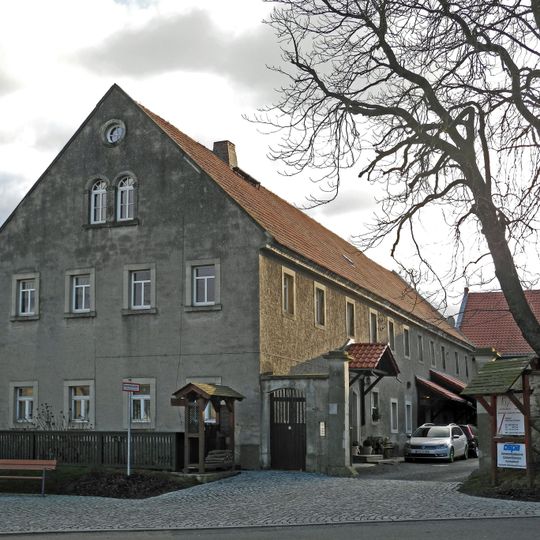 Dreiseithof mit Wohnstallhaus, Scheune und Seitengebäude, dazu Hofmauer mit zwei Torpfeilern und Pforte Dorfplatz 5