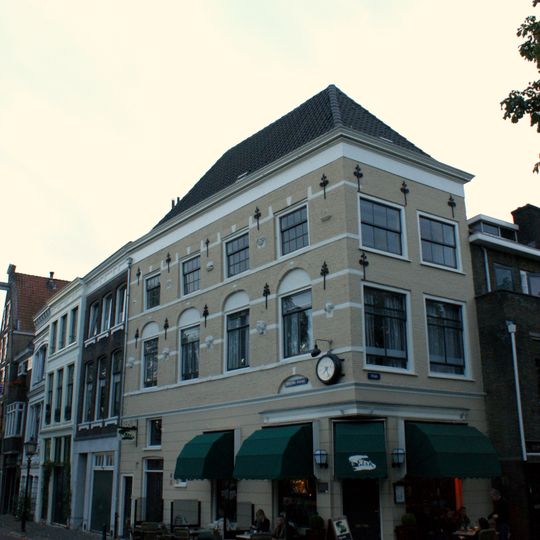 Hoekpand, hoog schilddak, bovendeel van een rijkversierde renaissance gevel met speklagen, ontlastingsbogen met sluitstenen