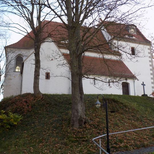 Kirche sowie ehemaliger Kirchhof mit Eisenkreuz auf Sockel vor der Kirche Höfgener Dorfstraße 7