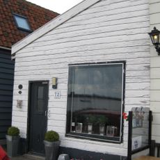 Houten huis met houtskelet, de voorste helft in de 19e eeuw met een verdieping verhoogd. Uitwendig aspect, met puntvormig voorschot, 19e-eeuws