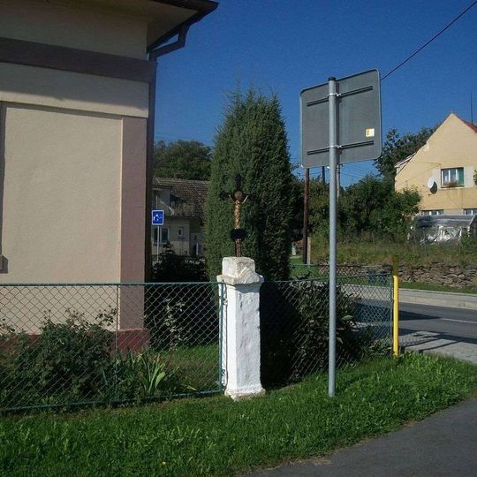 Kříž v Horní Bělé v plotě u čp. 15