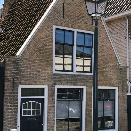 Laag pandje onder zadeldak tegen topgevel met vlechtingen