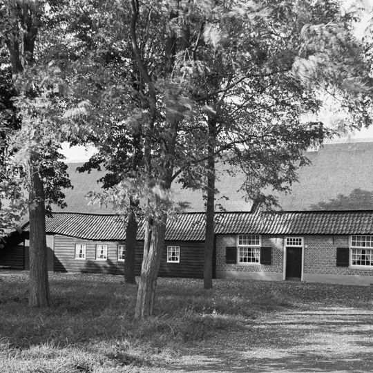 Fraaie langgevelboerderij met schaapskooi aan de voorkant. Wolfdak, gedekt door riet en pannen; vensters met 25 ruitsschuiframen en luikjes