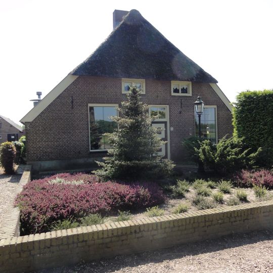 Boerderij met een door riet en pannen gedekt wolfdak