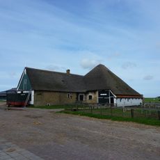 Zeer goed bewaarde gave stolp met groot uitgebouwd woonhuis; houten top met luik en versierde makelaar. In twee vertrekken lambrisering van witte tegels met blauwe rand