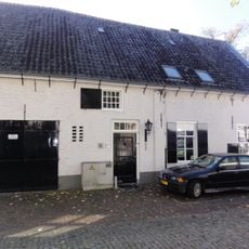 Huis met witte topgevel met vlechtingen