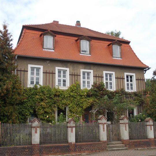 Wohnhaus mit zwei Seitengebäuden, Vorgarten und Einfriedung Dorfstraße 11