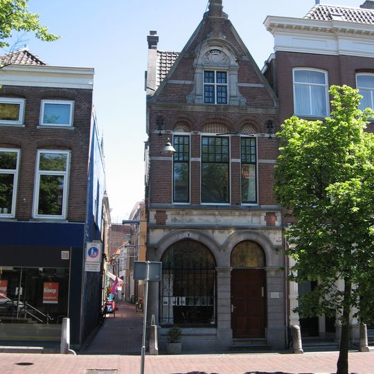 Voormalig bankgebouw met stoep en hek
