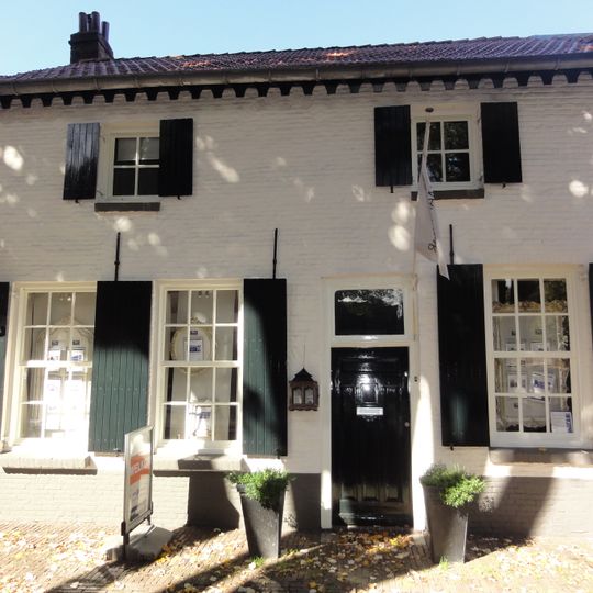 Huis met witgesausde lijstgevel en dwars zadeldak