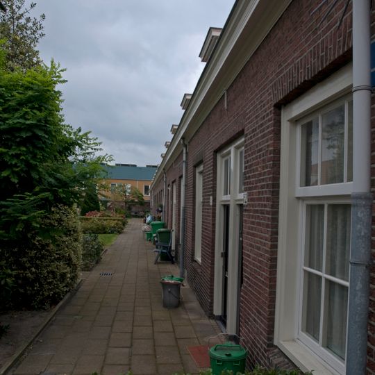 Dubbele rij van vierentwintig rug-aan-rug gebouwde woningen, op rechthoekige plattegrond bestaande uit een bouwlaag onder een met pannen gedekt mansardedak