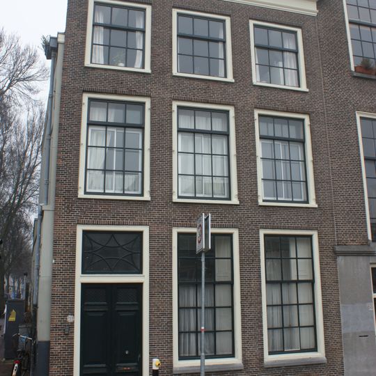 Pand met bakstenen gevel met rechte kroonlijst. Kleine roedeverdeling raam