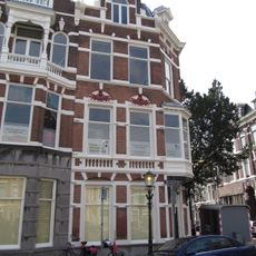 Hoekpand Reinkenstraat in neo-renaissance trant. Pand met afgeschuinde hoek en trapgevels, gedateerd op cartouches. Versiering van banden, blokken en ontlastingsbogen.