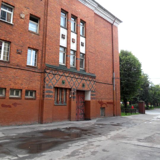 Здание Хуфенского лицея с головами двух девушек над входом