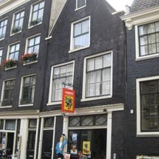 Koetshuis met puntgevel waarin deur en snijraam