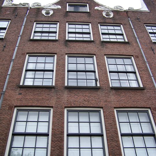 Huis, vanwege de zandstenen onderdelen van de klokvormige geveltop en de twee oeils-de-boeuf