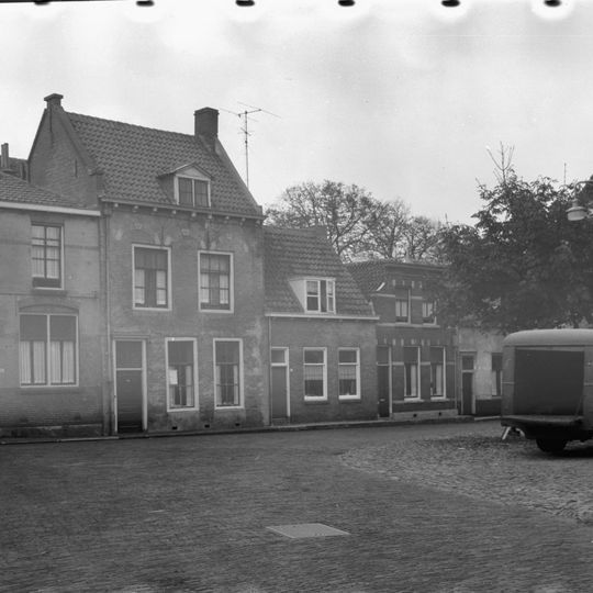 Huis met geverfde langsgevel, gootlijst op klossen