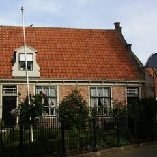 Eenvoudige woning onder zadeldak met toppilaster ter halverwege