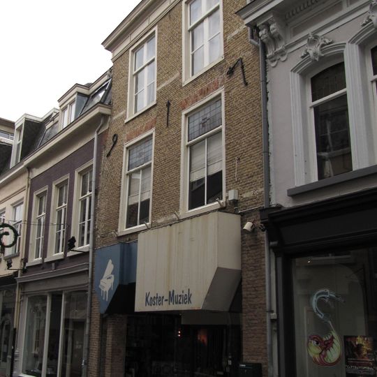 Huis met witgeschilderde lijstgevel en overblijfselen van jaarankers