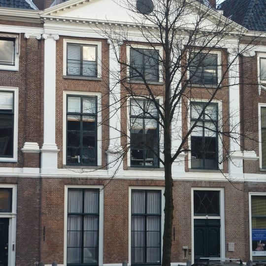 Pand met Ionische pilastergevel. Gevel met tympanon, gepleisterd. Stoephek met palen.