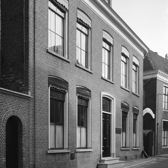 Deftig vijf traveeën breed pand met omlijste ingang in het midden