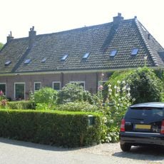 Pand met langgerekte lage gevel met zadeldak en rechte kroonlijst