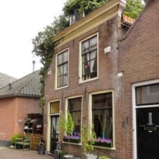 Pand met eenvoudige lijstgevel, geprofileerde lijst, oudere gevelstenen en jongere dakkapel