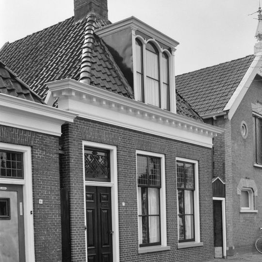 Pand met zesruitsvensters onder zadeldak met voorschild waarboven topschoorsteen met bord en drielichtsdakkapel