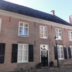 Woonhuis met verdieping en hoog zadeldak tussen zijtopgevels met vlechtingen