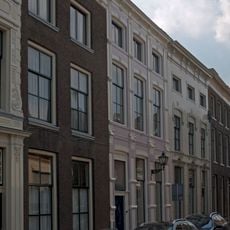 Pand met gepleisterde gevel, rechte kroonlijst en voordeur met amandelvormig paneel