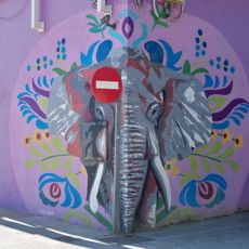 Mural con el retrato de un elefante visto de frente rodeado de elementos florales.
