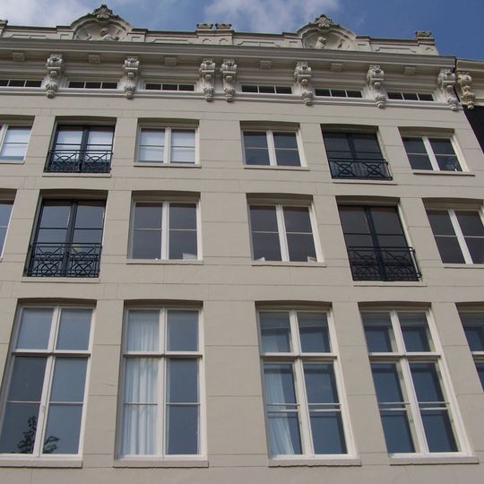 Pand met gevel onder zandstenen lijst met consoles en attiek waarin een tijger