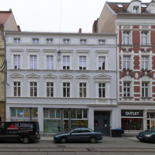 Wohn- und Geschäftshaus in geschlossener Bebauung, mit Resten originaler Schaufenster, und Hintergebäude Berliner Straße 26