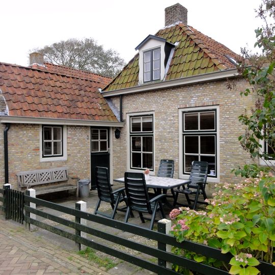 Pand zonder verdieping onder met pannen gedekt afgewolfd zadeldak