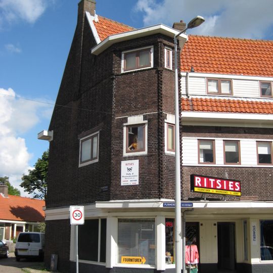 Blok met winkels met brede luifel en daarboven woningen, bouwstijl Amsterdamse School, onderdeel van het centrale achthoekige plein van Tuindorp Nieuwendam