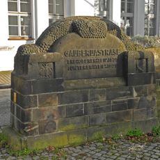 Eingemeindungsgedenkstein, Relief des diebischen Rabens und Stützmauer