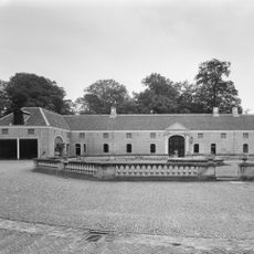 Twickel: achthoekige natuurstenen balustrade waarvan de vier doorgangen met acht identieke gietijzeren tuinvazen voorplein die grijs geschilderd zijn