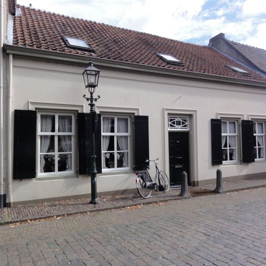 Wit dorpshuis, zadeldak van rode pannen met nok evenwijdig aan de gevel