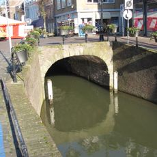 Damoverkluizing. De overwelving heeft aan de zijde van de Haven een boog met natuurstenen blokken en een balustrade