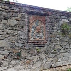 Nápisová deska s erbem na zámecké zdi ve Štekni