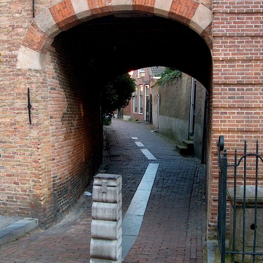 Poortje. Eenvoudige bakstenen poortomlijsting toegang gevend tot het Klooster