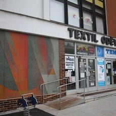 Skleněná mozaika na fasádě nákupního střediska textil - oděvy