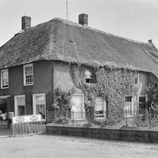 Pand onder omlopend rieten schilddak. In de verdieping en in de zijgevels vensters met goede roedenverdeling.