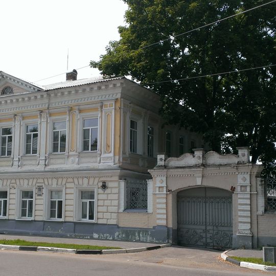 Кирпичная ограда с двумя воротами и коваными решетками