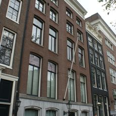 Pand met vierraamsgevel in traditionele vormen, onder rechte lijst met consoles