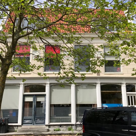 Breed pand onder dwarsdak met gepleisterde gevel en drie grote gevelstenen