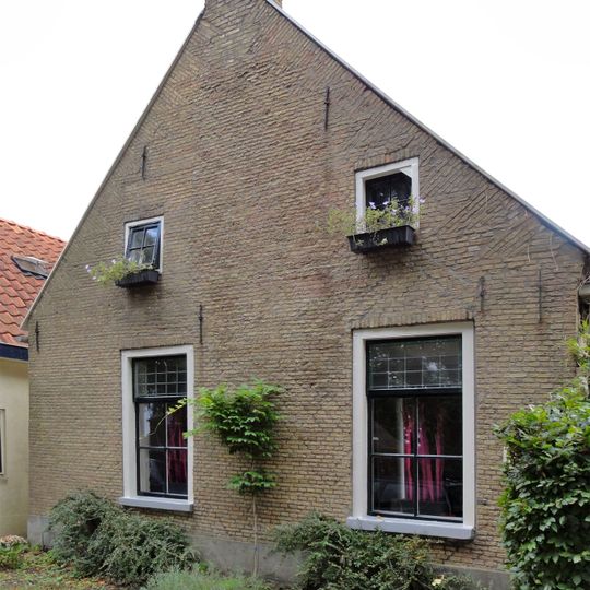 Kop-rompboerderij met topschoorsteen met bord